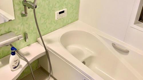 富士河口湖貸別荘 ウサギの郷的浴室设有位于水槽旁的白色浴缸。