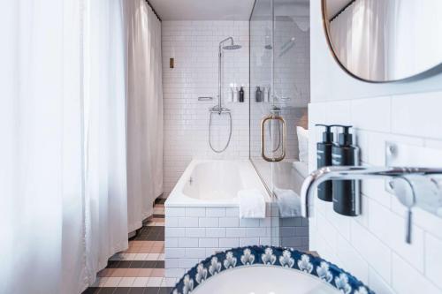 斯德哥尔摩Story Hotel Riddargatan, part of JdV by Hyatt的带浴缸、淋浴和盥洗盆的浴室