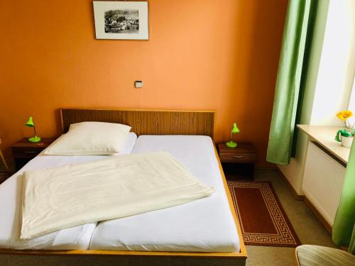 SchalksmühleHotel zur Post的一间卧室设有两张床和橙色的墙壁
