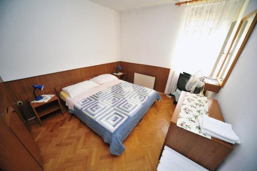 奥帕提亚Rooms Novaković的一间小卧室,配有一张床和一张桌子