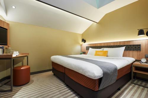 新加坡Dash Living Rochor的酒店客房设有一张大床和一台电视。