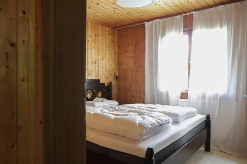 斯卡尔尼茨Scharnitz Chalet - gut eingerichtetes Haus的一间卧室配有一张带白色床单的床和一扇窗户。