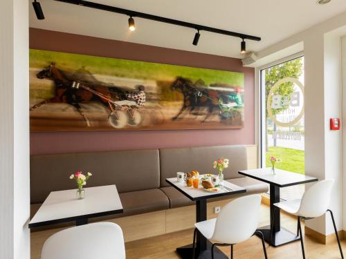 门兴格拉德巴赫门兴格拉德巴赫住宿加早餐酒店的餐厅设有两张桌子,墙上挂着一幅画