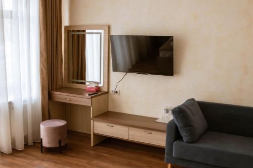第聂伯罗Graff Hotel的客厅配有沙发和墙上的电视