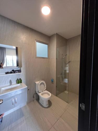古晋Modern Stylish Apartment near Kuching Airport的浴室配有卫生间、盥洗盆和淋浴。