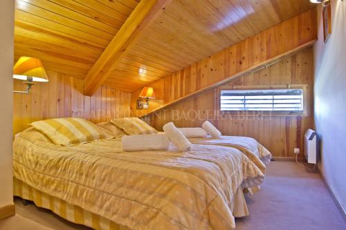 巴奎伊拉-贝莱特阿巴达伦特1500号公寓的木制客房内的一间卧室配有一张大床