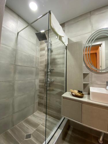泰拉维Kera Rooms的带淋浴、盥洗盆和镜子的浴室