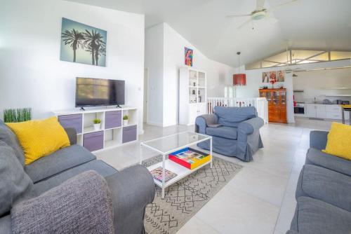 格罗斯岛Reduit Orchard - Beautiful Home near Reduit Beach的客厅配有2张蓝色沙发和电视
