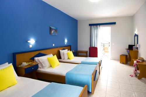 拉加纳斯Hera Zakynthos Hotel的酒店客房设有两张床和蓝色的墙壁。