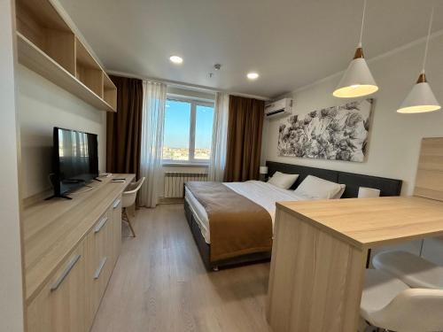 塔尔迪科尔Apart Astana的一间卧室配有一张床、一台电视和一张书桌