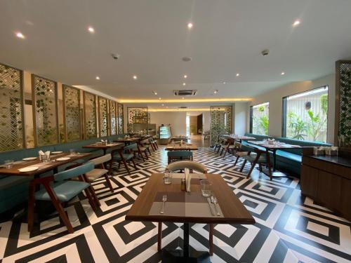 古瓦哈提Sachika Hotels, Guwahati的餐厅内带桌椅的用餐室