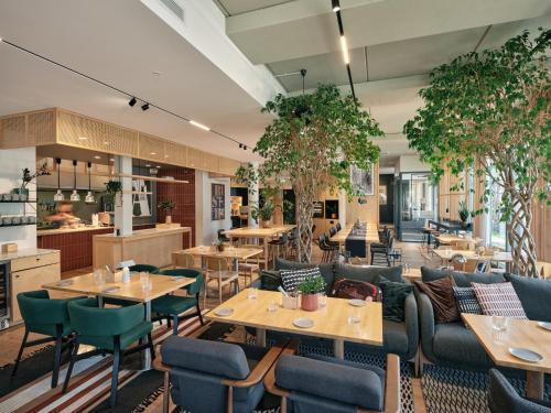 塔林Oru Hub Hotel Tallinn - Handwritten Collection的一间带桌椅的餐厅和一间自助餐厅