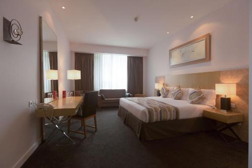 卡迪夫公园广场加的夫酒店的配有一张床和一张书桌的酒店客房