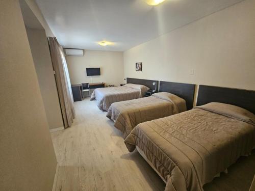 门多萨DAKAR HOTEL的酒店客房设有两张床和电视。