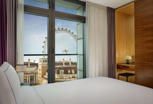 伦敦伦敦市政厅公园广场酒店的一间卧室设有大窗户,享有伦敦的美丽景致。