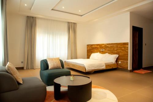 科托努RÉSIDENCE ALICE COTONOU的酒店客房带一张床、一张桌子和椅子
