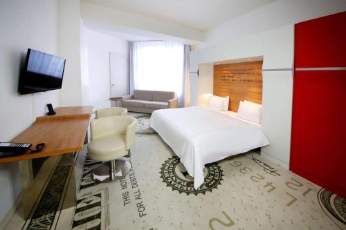 柏林华尔街柏林公园广场酒店的一间酒店客房,配有一张白色的床和一张书桌