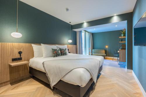 瓦瑟纳尔凡德瓦克酒店的一间卧室设有一张大床和绿色的墙壁