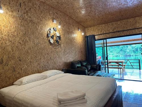 Tha Kradanธารามนตรา รีสอร์ท (Taramontra resort)的卧室配有床、椅子和窗户。