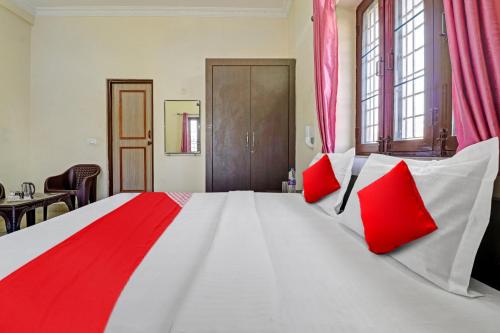 德拉敦Balindira Guest House的大卧室配有一张带红色枕头的大床
