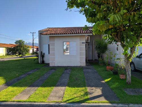 帕罗卡Casa na Grande Florianopolis的一座带草地庭院的白色小房子