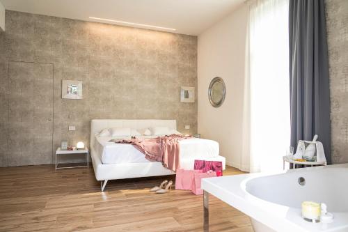 蒙扎Villa Tosati的卧室配有白色的床和浴缸