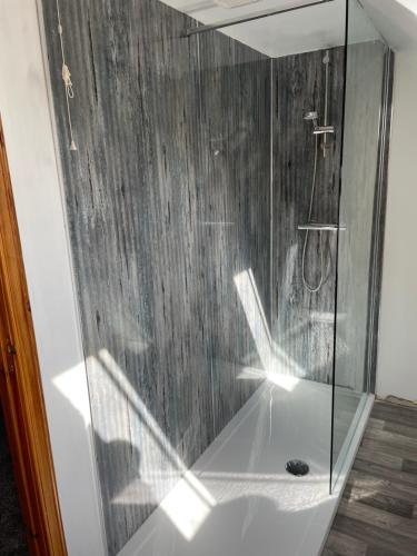 威克3 Bedroom Townhouse on NC500, Wick, Highland的浴室里设有玻璃门淋浴