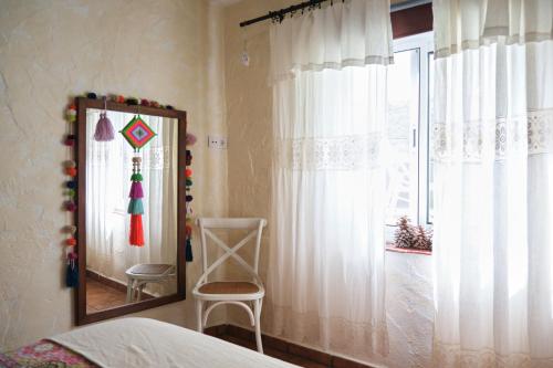 La GuanchaCuarto Verode Apartamento Santo Domingo的一间卧室配有镜子、椅子和窗户