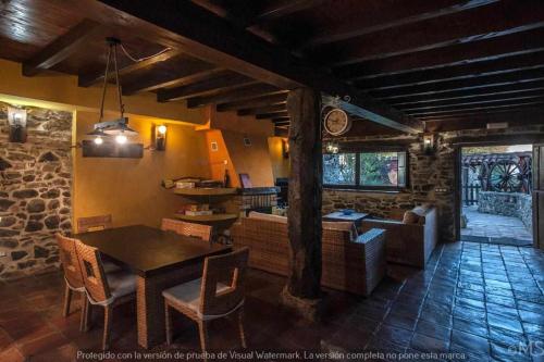 TriolloCasa rural la corva的厨房以及带桌椅的起居室。
