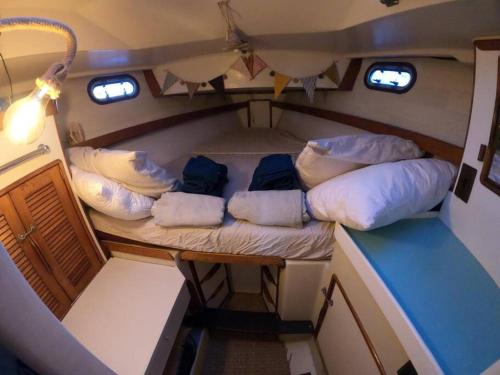 格吕桑Voilier traditionnel, tout confort et au calme的小房间,船上有枕头