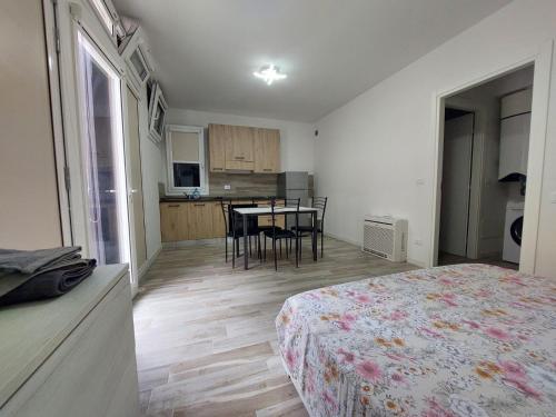 博洛尼亚Levante Suite的一间卧室配有一张床,厨房配有桌子