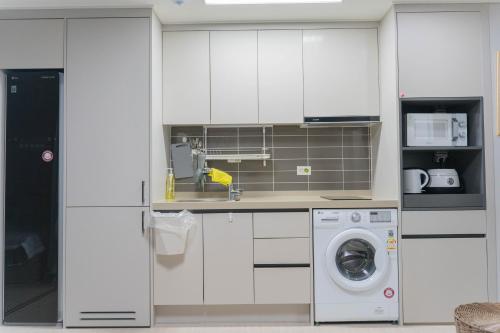 东海市KK Stay Ocean view with Netflix的厨房配有白色橱柜和洗衣机。