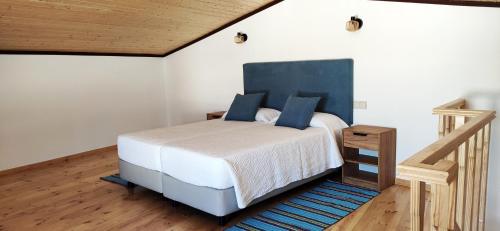 圣巴托洛梅乌迪梅西尼什Familia Sequeira的一间卧室配有一张蓝色床头板的床