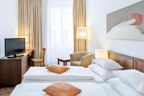 维也纳Hotel Rathauspark Wien, a member of Radisson Individuals的酒店客房设有两张床和电视。