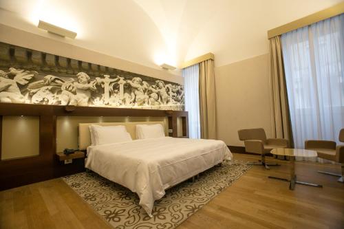 莱切Risorgimento Resort的卧室配有一张大床,墙上挂有绘画作品