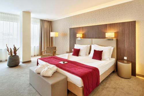 林茨Hotel Schillerpark Linz, a member of Radisson Individuals的酒店客房设有一张带红色毯子的大床