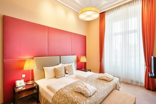 维也纳Austria Trend Hotel Savoyen Vienna - 4 stars superior的一间卧室设有一张红色墙壁的大床