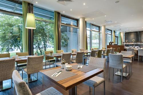 维也纳维也纳多皮奥奥地利时尚酒店的餐厅设有桌椅和窗户。