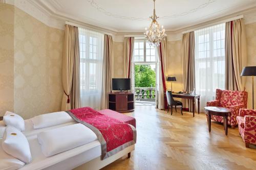 维也纳维也纳美泉宫奥地利时尚公园酒店的一间卧室配有一张床,客厅配有桌子