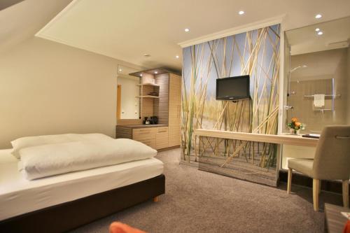胡苏姆Boutiquehotel Myn Utspann的一间卧室配有一张床、一张书桌和一台电视