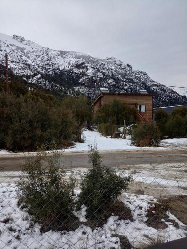 圣卡洛斯-德巴里洛切Tiny house Bariloche的雪覆盖的山前的围栏