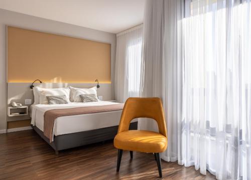 圣保罗Blue Tree Towers Anália Franco - Tatuapé的一间卧室配有一张床和一张黄色椅子