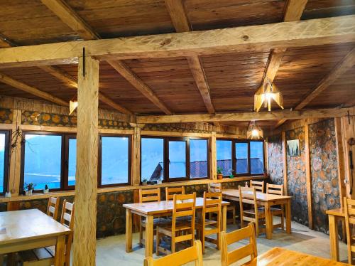 ChʼkhakouraPanorama Bakhmaro的用餐室设有木桌、椅子和窗户。