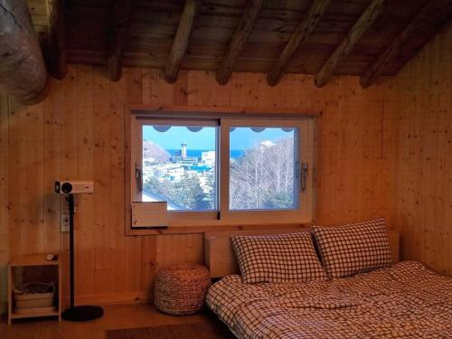 东海市Donghae Hanok Stay的一间卧室设有一张床和一个窗口