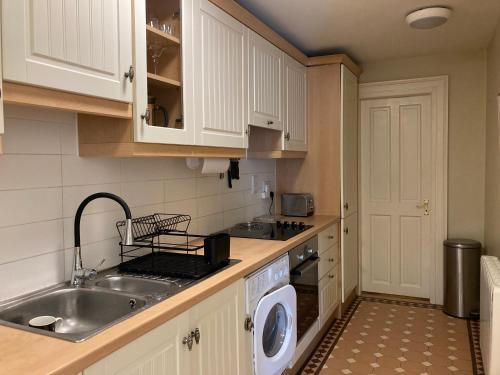 科芙Self Catering Apartment- 11A Westbourne Place的厨房配有水槽和洗衣机