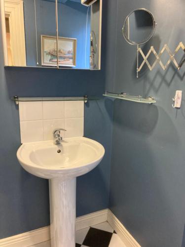 科芙Self Catering Apartment- 11A Westbourne Place的浴室设有白色水槽和镜子