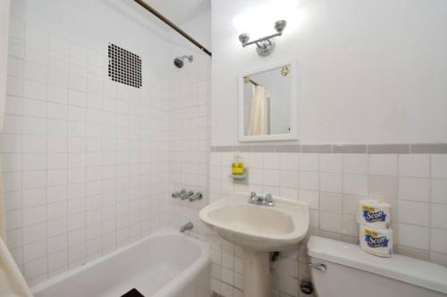 纽约Beautiful 2BR/1BA in Heart of NYC的白色的浴室设有水槽和浴缸。