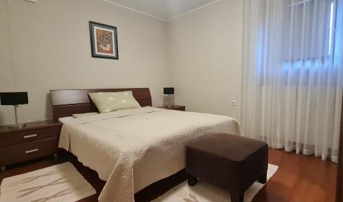代尔尼采Apartman Neli的一间卧室设有一张大床和一个窗户。