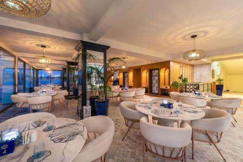 RizokarpasoBlue Sea Karpasia Hotel的一间设有白色桌子和白色椅子的餐厅