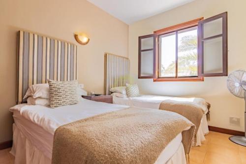 普拉亚布兰卡Mountain View Villa的带三张床和窗户的客房